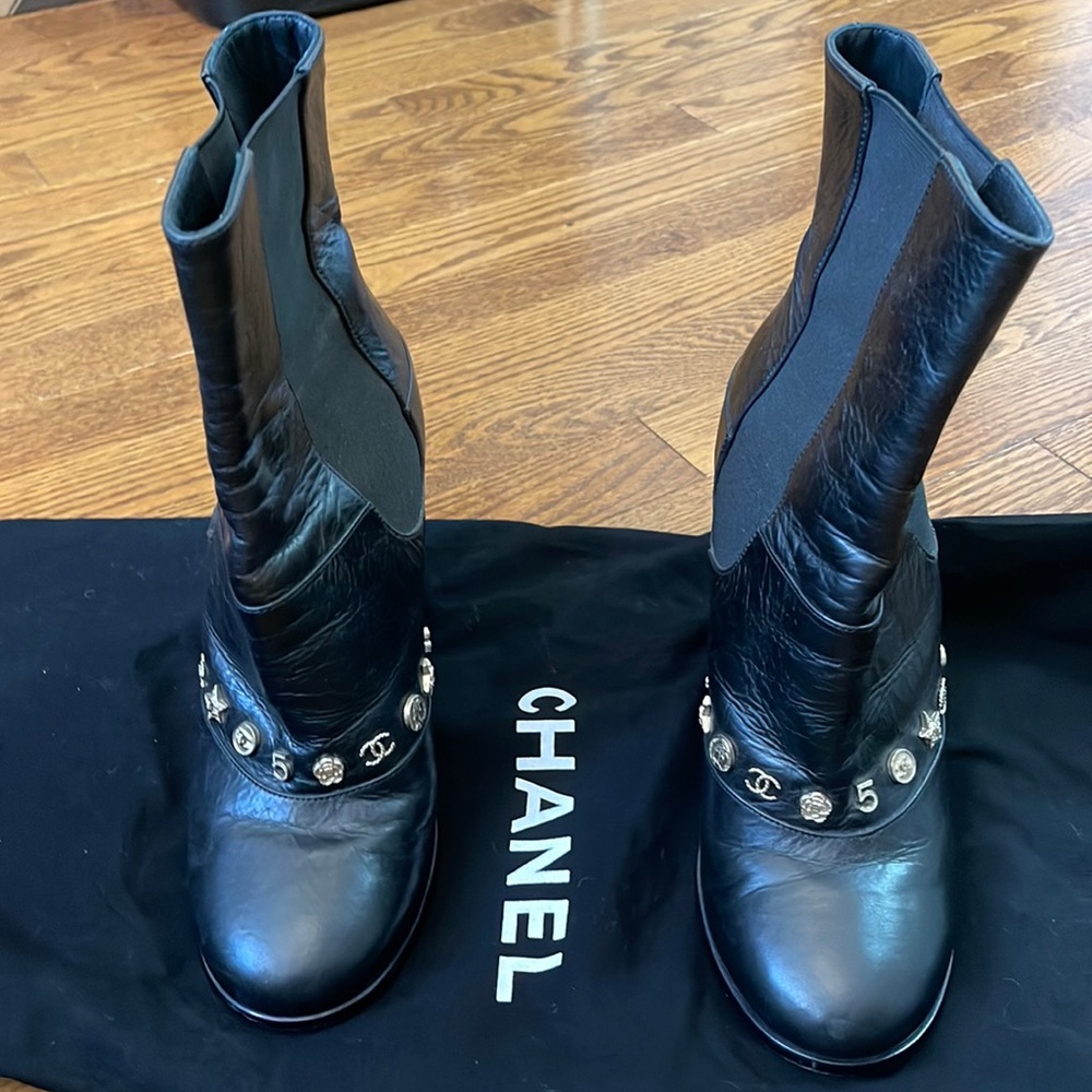 Channel Leather boots with charms on the front of the boot.